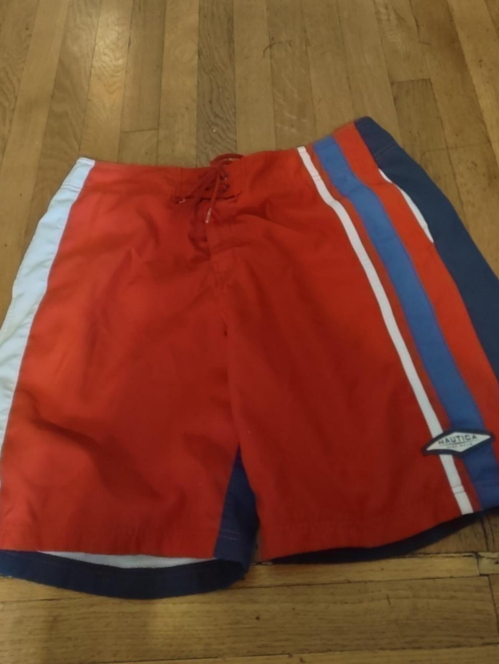 red swim trunks with navy blue back and blue and white stripes from nautica 36W